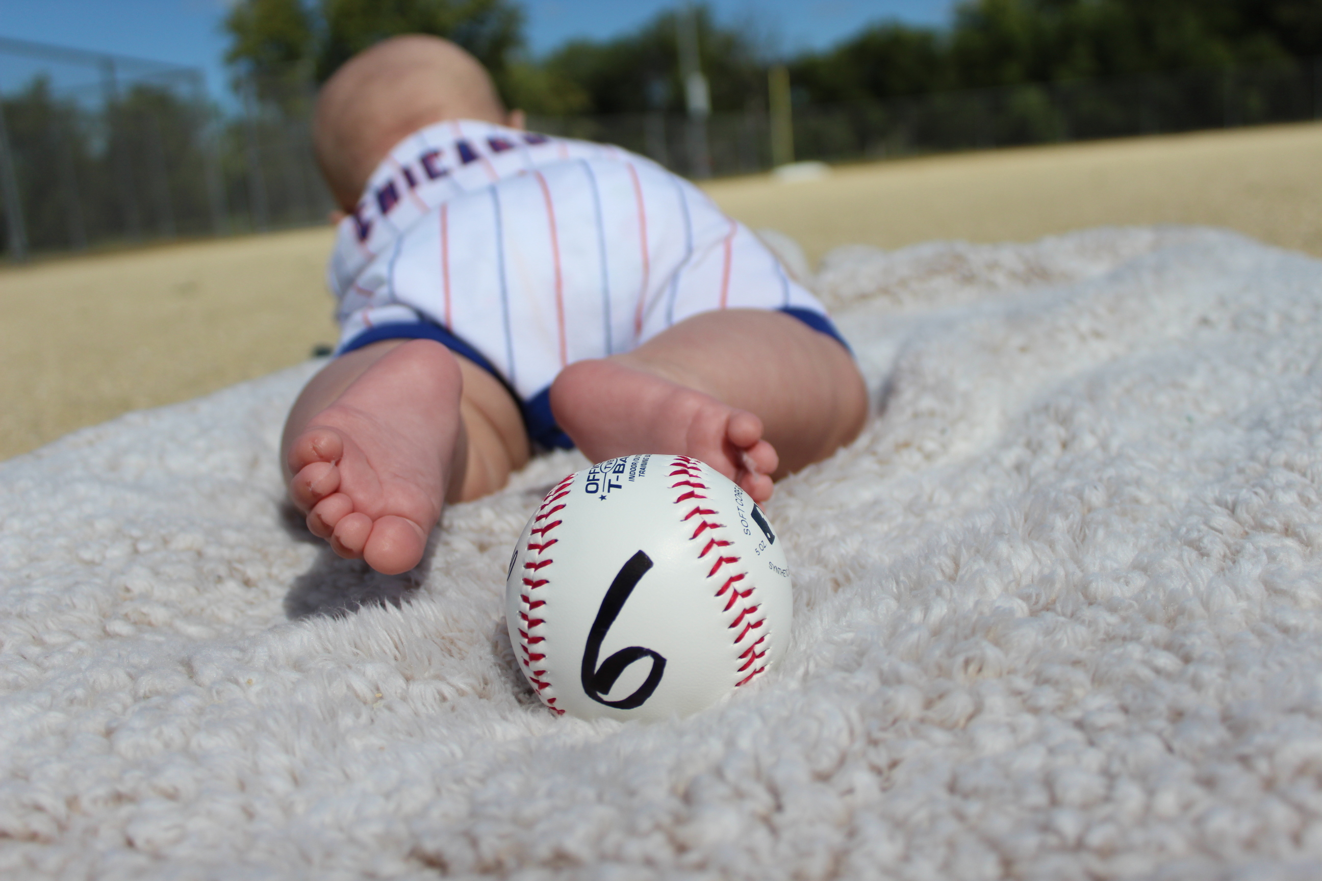 A woman in a wedding dress is standing in front of the sea on the rocks.