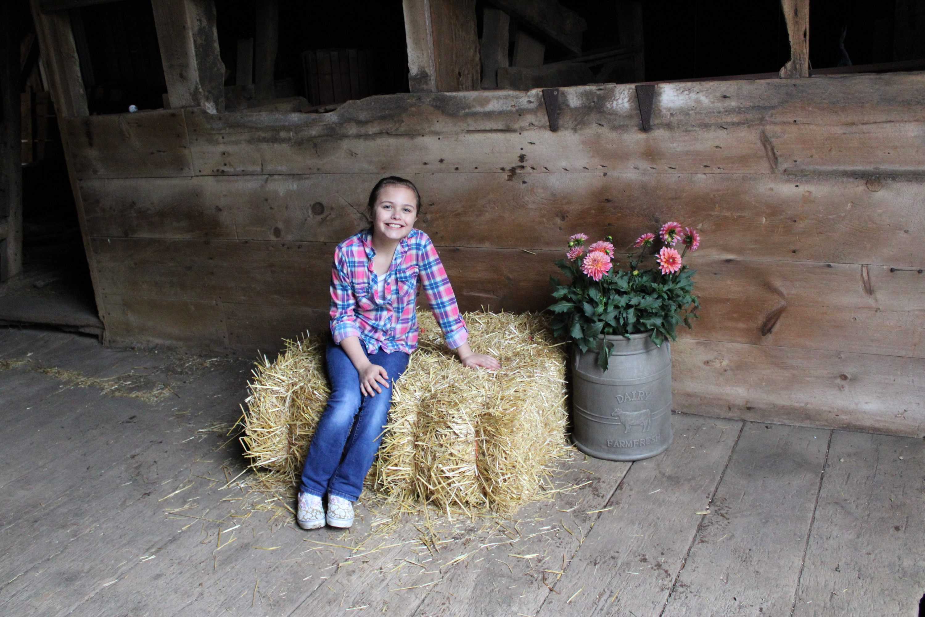 A woman in a wedding dress is standing in front of the sea on the rocks.