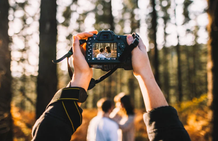 Black and white photo of a woman in a wedding dress in a room in front of a mirror from the back.